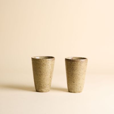 une paire de deux tasses posées l'une à côté de l'autre sur une surface blanche