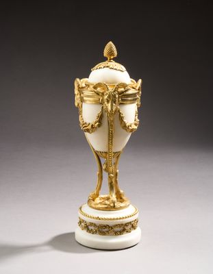 a white and gold vase on a white table