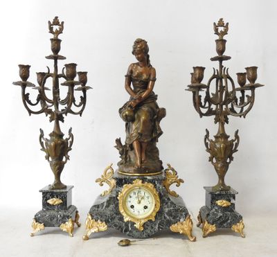a statue of a woman sitting on top of a clock