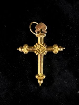 a close up of a gold cross on a black background