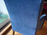 a blue chair that is sitting in front of a window