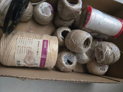de nombreuses bobines de fil et des ciseaux dans une boîte