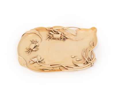 une assiette en or décorée d'un oiseau et de fleurs