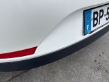 the rear end of a white car with a number plate on it ' s bumper