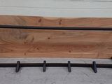 a wooden bench with a metal frame and hooks on it