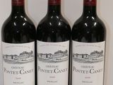 three bottles of red wine are lined up on a table