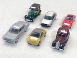 several toy cars are lined up in a row on a white surface