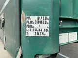un camion-benne vert garé sur le bord de la route
