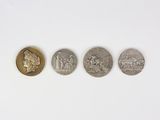 four different types of coins on a white surface