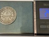 a silver coin sitting on top of a black book