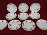 six assiettes blanches et rouges ornées de fleurs, posées sur une nappe rouge