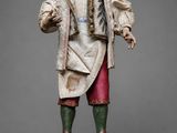 une statue représentant un homme vêtu d'une blouse blanche et d'un pantalon rouge