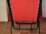 a red and black chair with a red blanket on top of it