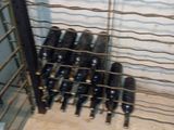 de nombreuses bouteilles de vin posées dans un casier posé à même le sol