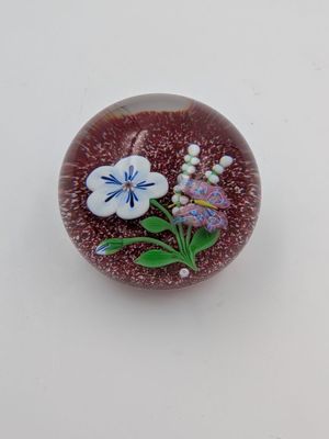 un petit objet en verre orné d'une fleur