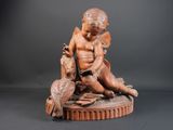 statue représentant un garçon avec un oiseau posé sur une table