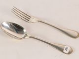two silver spoons and a fork on a table