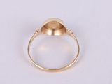 a close up of a gold ring on a white surface