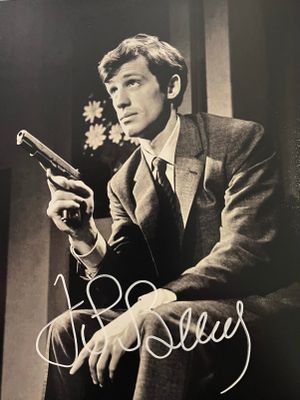 une vieille photo d'un homme en costume tenant un pistolet