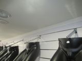 a row of wetsuits hanging on a rack in a store