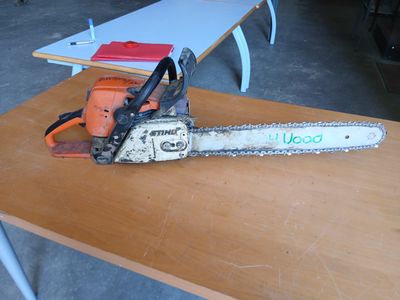 une tronçonneuse posée sur une table dans une pièce