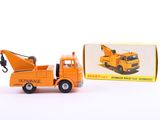 an orange toy truck with a crane in front of a box