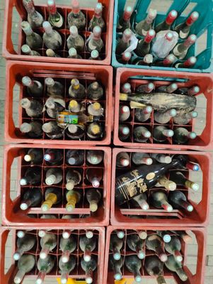 des bouteilles et des cuillères rangées dans des bacs en plastique empilés les uns sur les autres