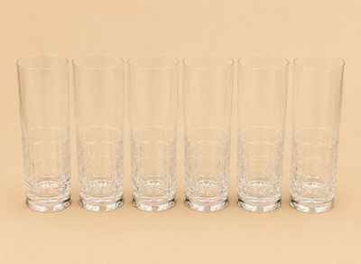 six verres sont alignés sur une surface beige