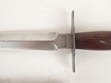 a knife with a wooden handle on a white surface