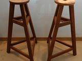 deux tabourets en bois placés l'un à côté de l'autre dans une pièce