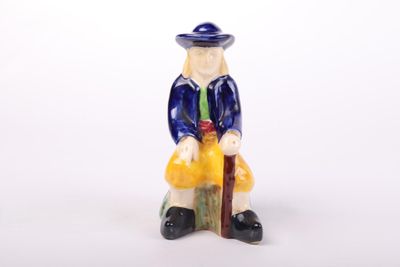 a figurine of a man sitting on a bench