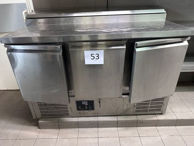un plan de travail en acier inoxydable dans une cuisine, sur lequel est posée une étiquette de prix