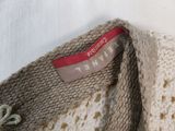 a close up of a crocheted sweater with a tag on it