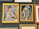 many framed pictures on the wall of a room