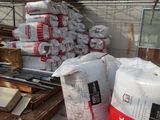 de nombreux sacs de ciment posés par terre dans un entrepôt