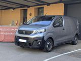 une camionnette argentée garée sur un parking à côté d'un immeuble