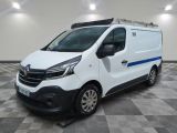 une camionnette blanche avec une bande bleue garée dans une pièce
