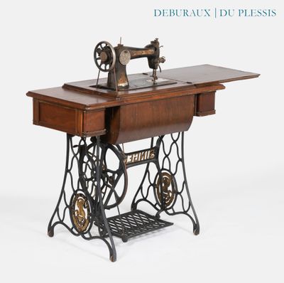 une vieille machine à coudre posée sur une table en bois
