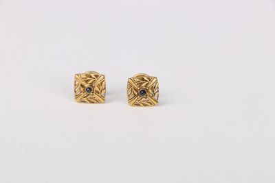 a pair of gold earrings with black diamonds