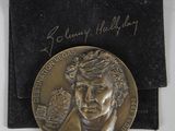 une image représentant une médaille d'or sur laquelle figure le portrait d'un homme