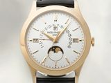 une montre-bracelet en or avec un cadran blanc et un bracelet en cuir noir