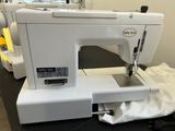 a white sewing machine sitting on a table in a room