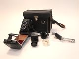 un sac noir sur lequel se trouvent un appareil photo et d'autres objets