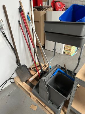 un seau et une pelle posés sur une palette dans un garage