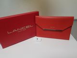a red box and a red wallet sitting on top of a white table