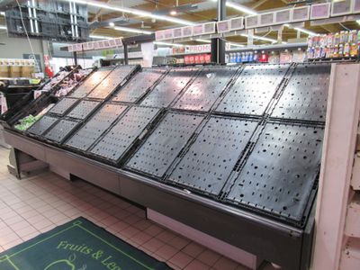 a large display case in a grocery store filled with fruits and veggies