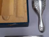 a silver comb and a silver comb in a blue box