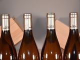 four bottles of wine are lined up in a row in front of a box