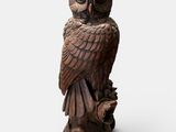 une statue de chouette perchée sur une souche d'arbre
