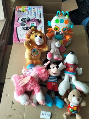 de nombreuses peluches dans une boîte en carton posée par terre